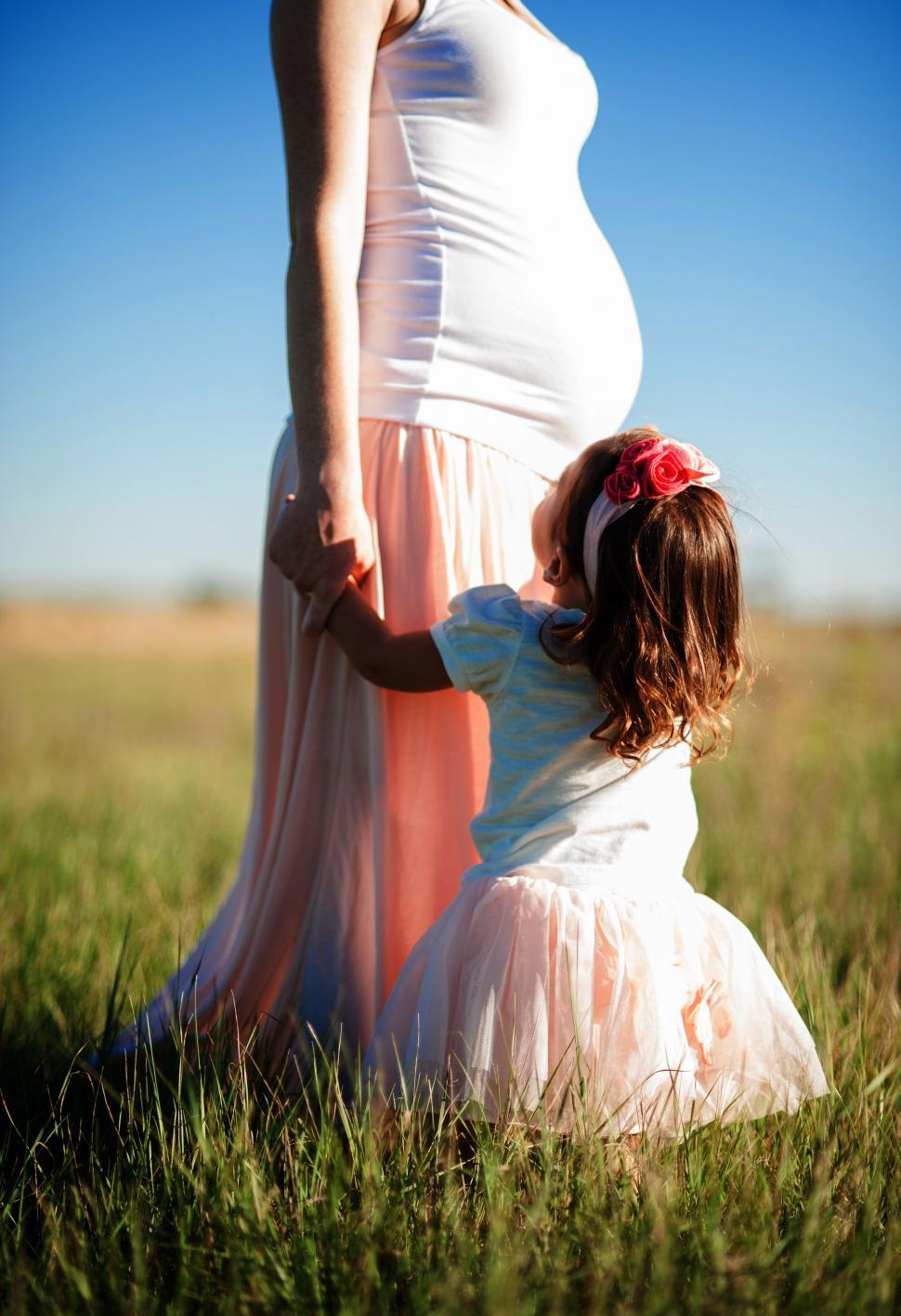 Free Image of Pregnant Woman Holding Hand of Young Girl 