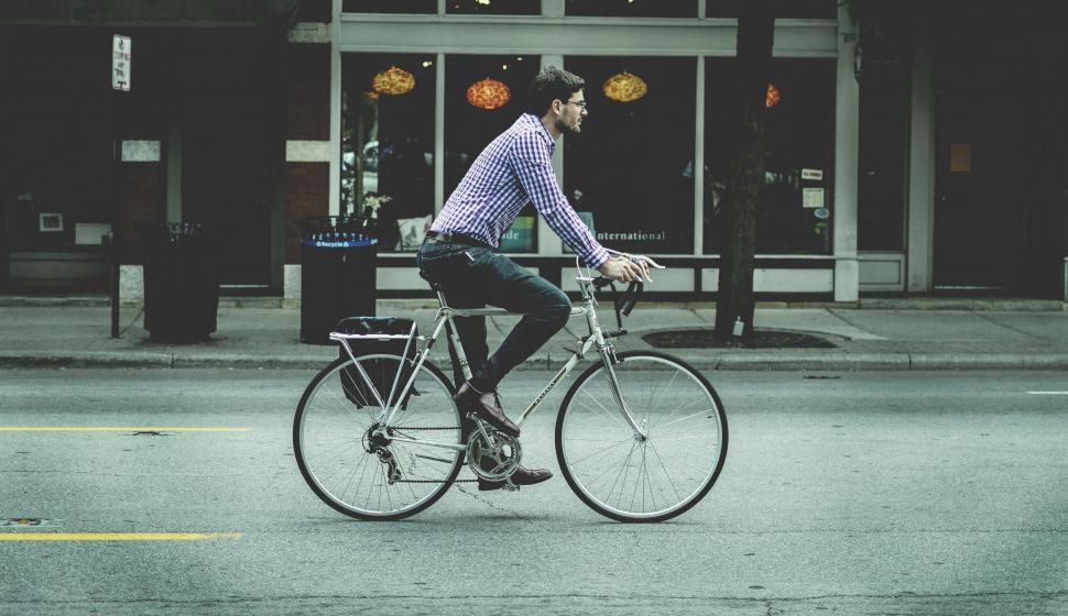 Free Image of Man Riding Bike Down Urban Street 