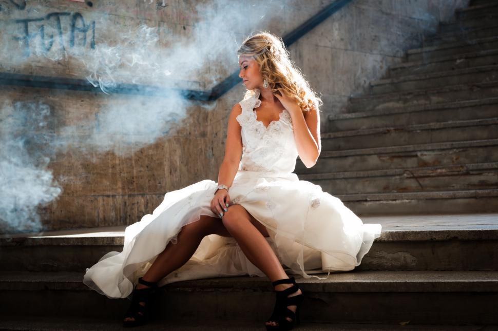 Free Image of Woman in White Dress Smoking Cigarette 