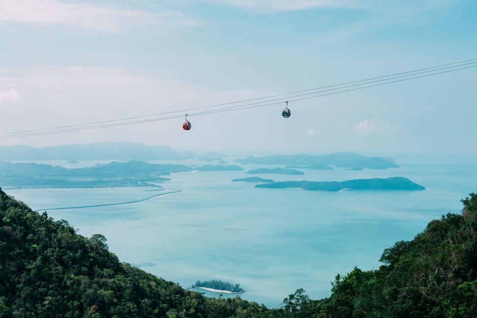 Free Image of Gondolas Flying Over Large Body of Water 