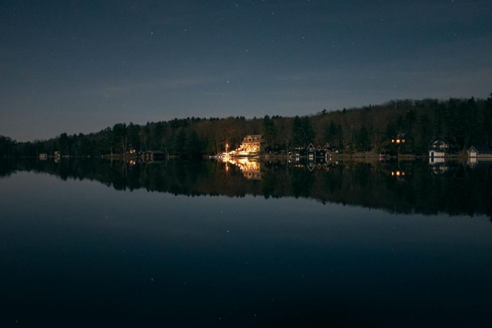 Free Image of Nighttime Waterfront Scene With Trees Along Shore 