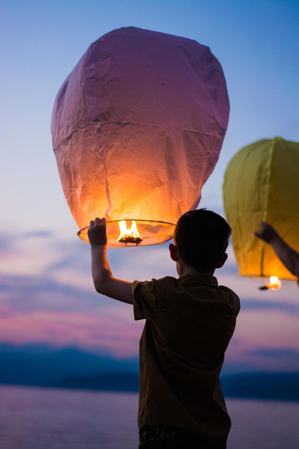 Free Image of Boy Holding Lantern in the Air 