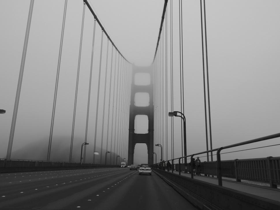 Free Image of Car Driving Across Bridge in Fog 