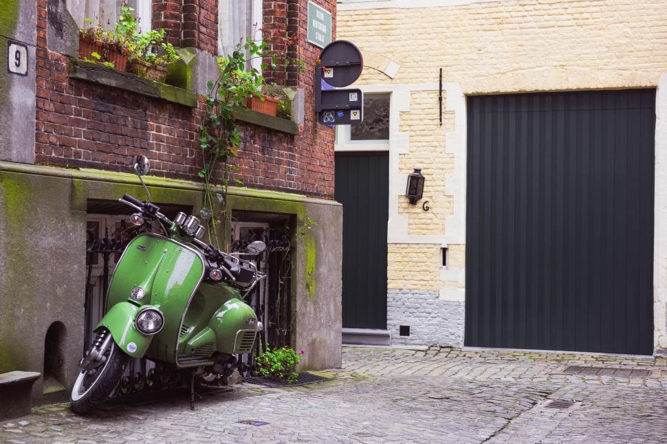 Free Image of Green Motorcycle Parked in Front of Building 