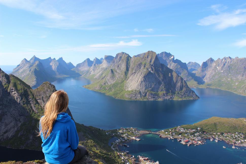 Free Image of Woman Sitting on Top of Mountain Overlooking Lake 