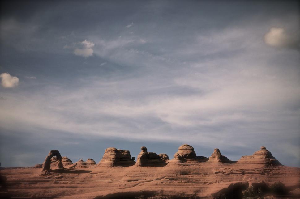 Free Image of Group of Rocks in Desert Under Cloudy Sky 