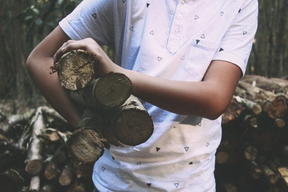 Free Image of Man Holding a Bunch of Logs 