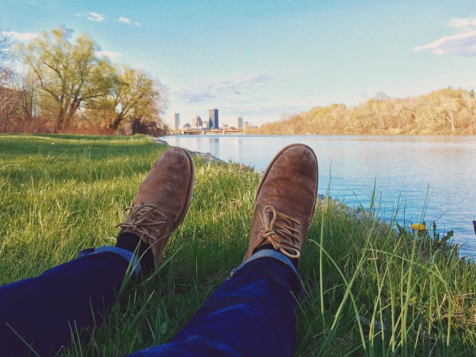 Free Image of Persons Feet in the Grass by Body of Water 