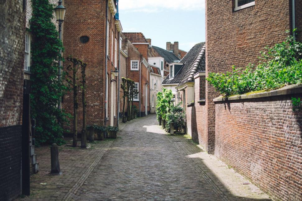 Free Image of Narrow Cobblestone Street Lined With Brick Buildings 