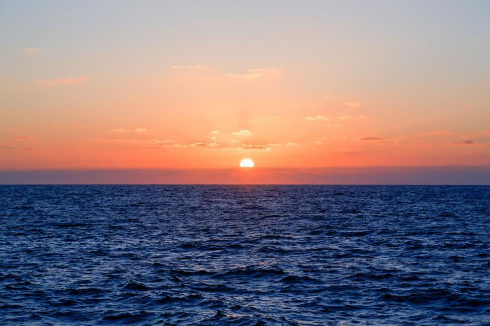 Free Image of The Sun Setting Over the Ocean From a Boat 