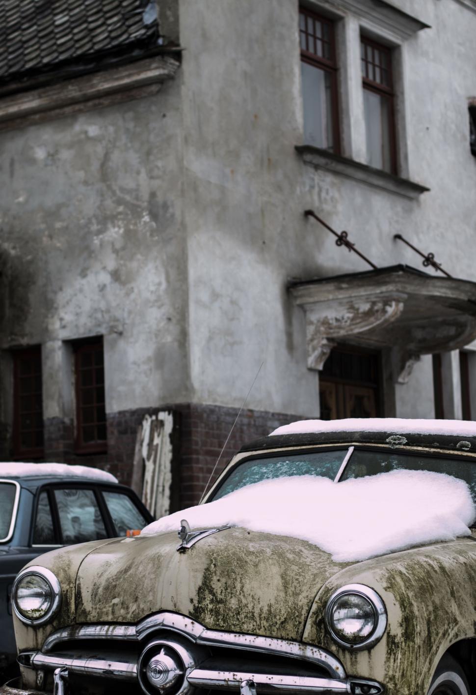 Free Image of Old Car Covered in Snow Parked in Front of Building 