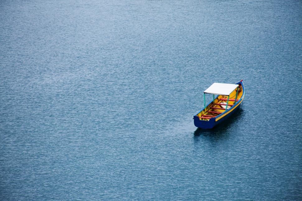 Free Image of Small Boat Floating on Large Body of Water 