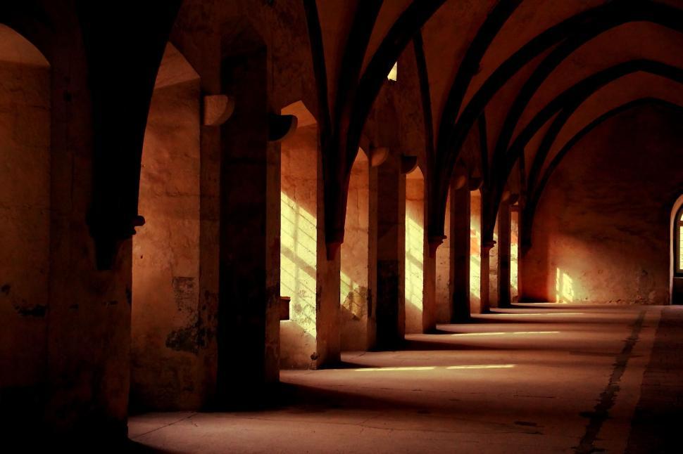 Free Image of Dimly Lit Hallway With Arches and Windows 