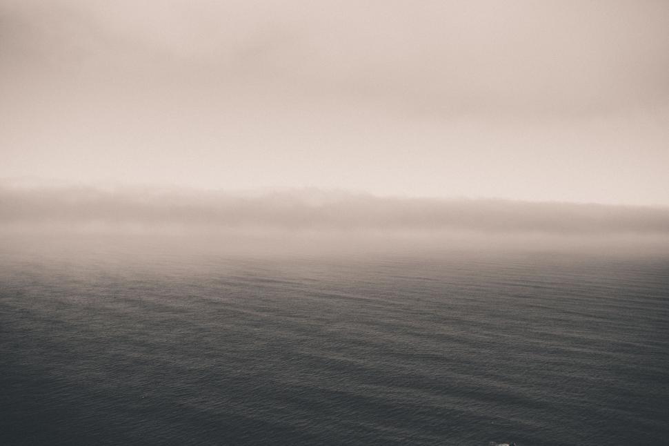 Free Image of A Moody Black and White Photo of a Foggy Ocean 