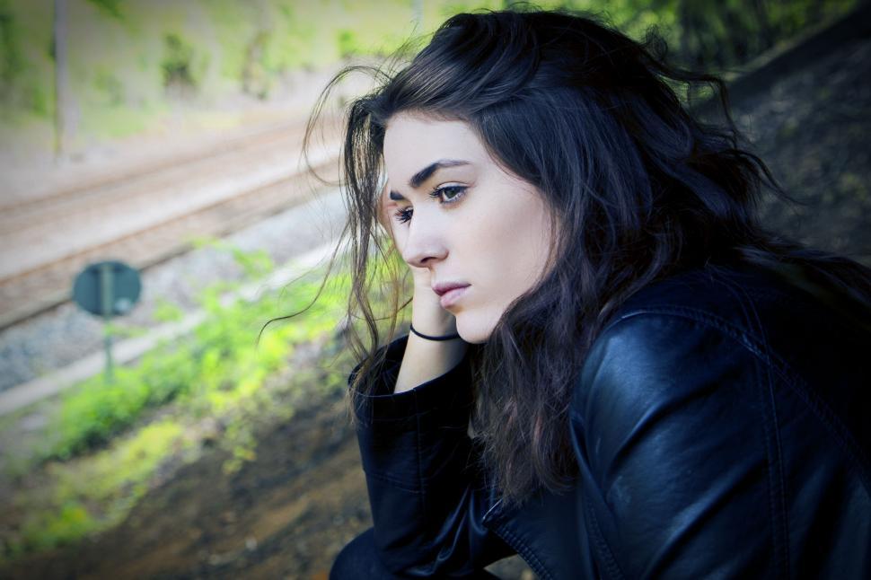 Free Image of Woman With Long Hair Sitting on a Bench 