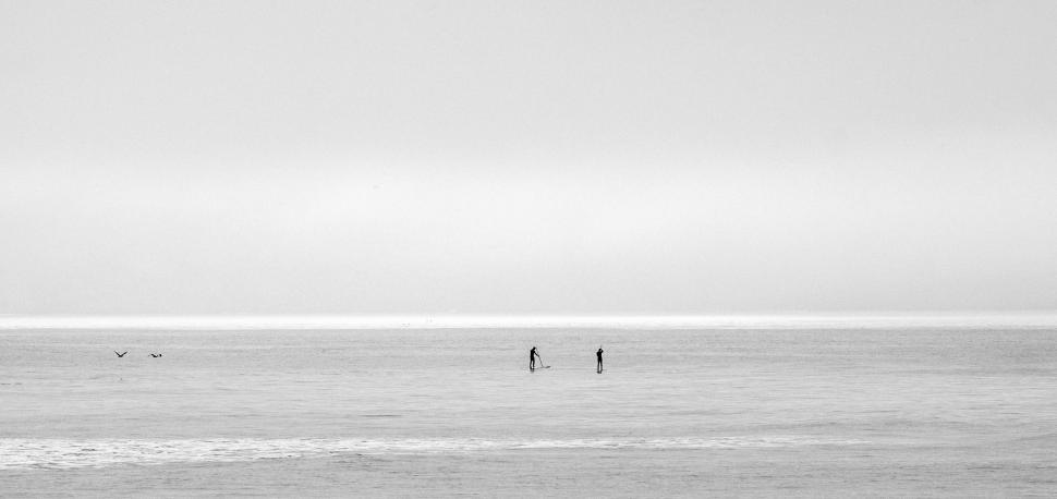 Free Image of Couple Standing on Beach Near Ocean 