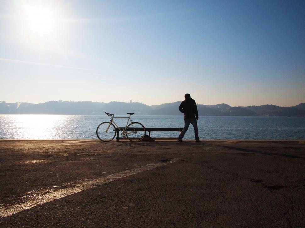 Free Image of Man Standing by Bike at Waters Edge 