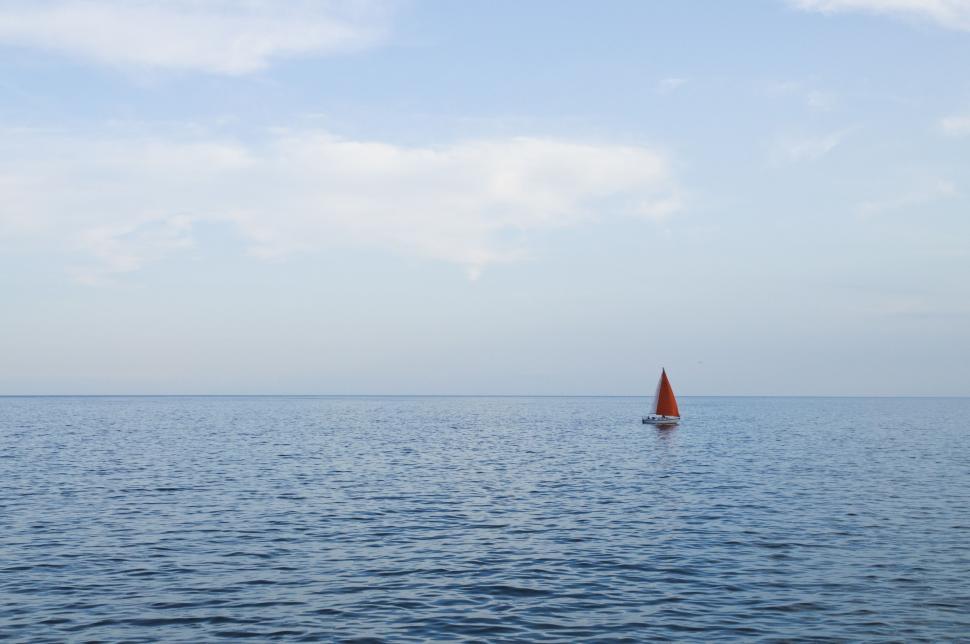 Free Image of Small Sailboat Sailing in Vast Open Water 