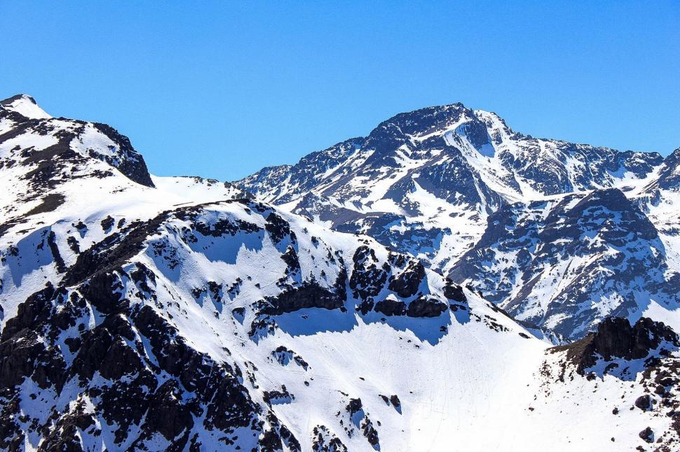 Free Image of Snow-Covered Mountain Range Under Blue Sky 