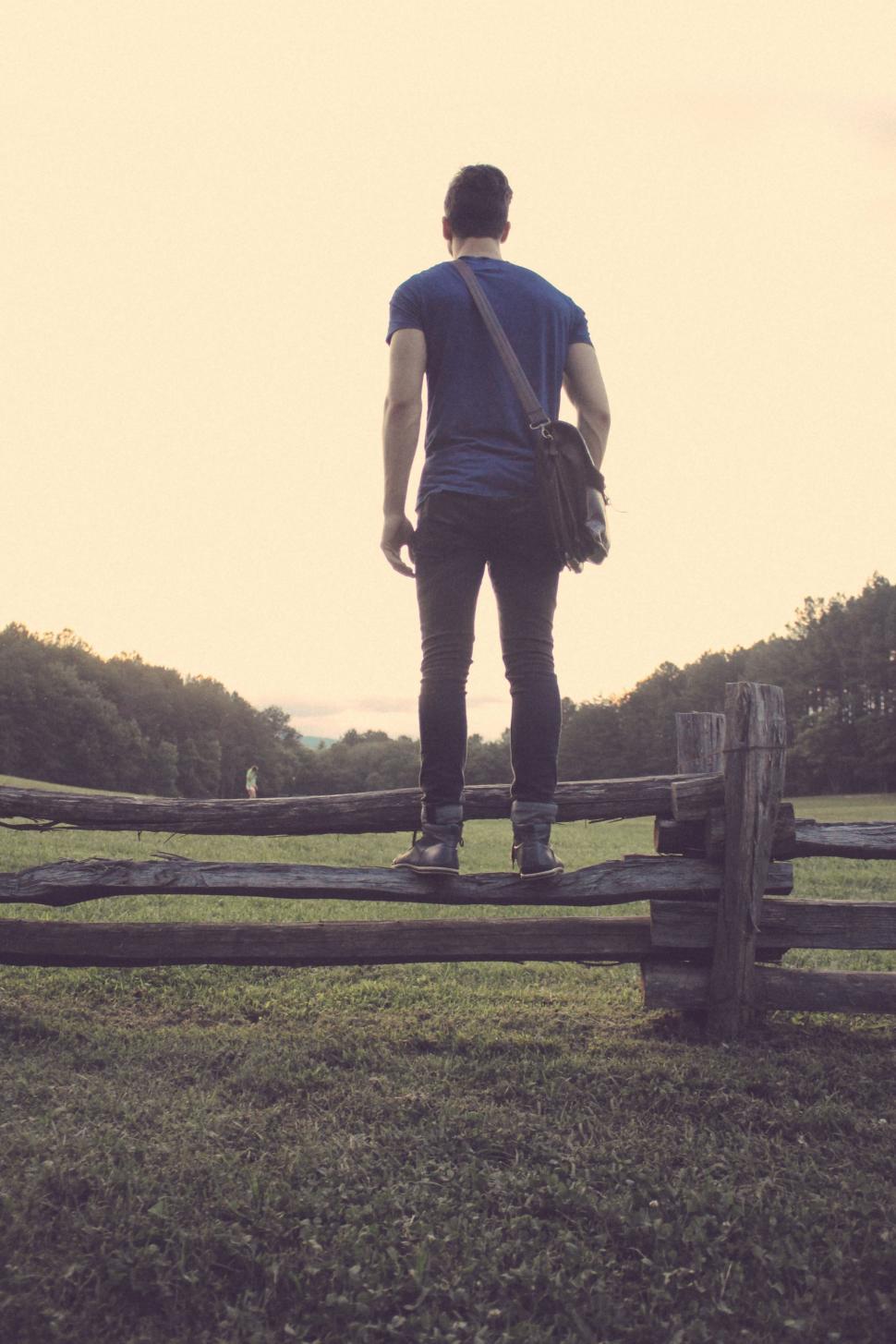 Free Image of Man Standing on Top of Wooden Fence 