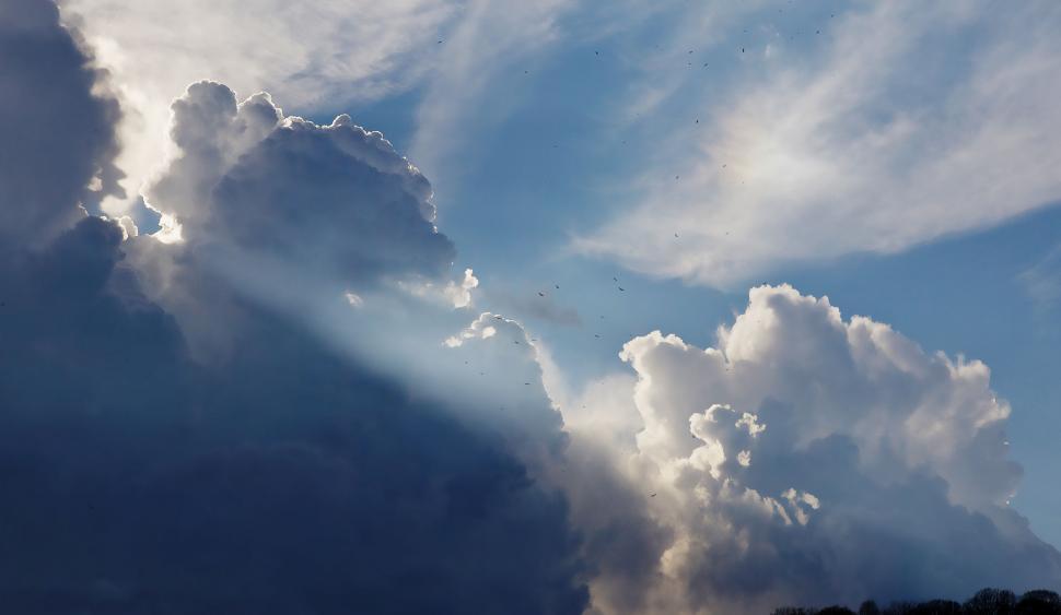 Free Image of Large Cloud Hovering Above Hill 
