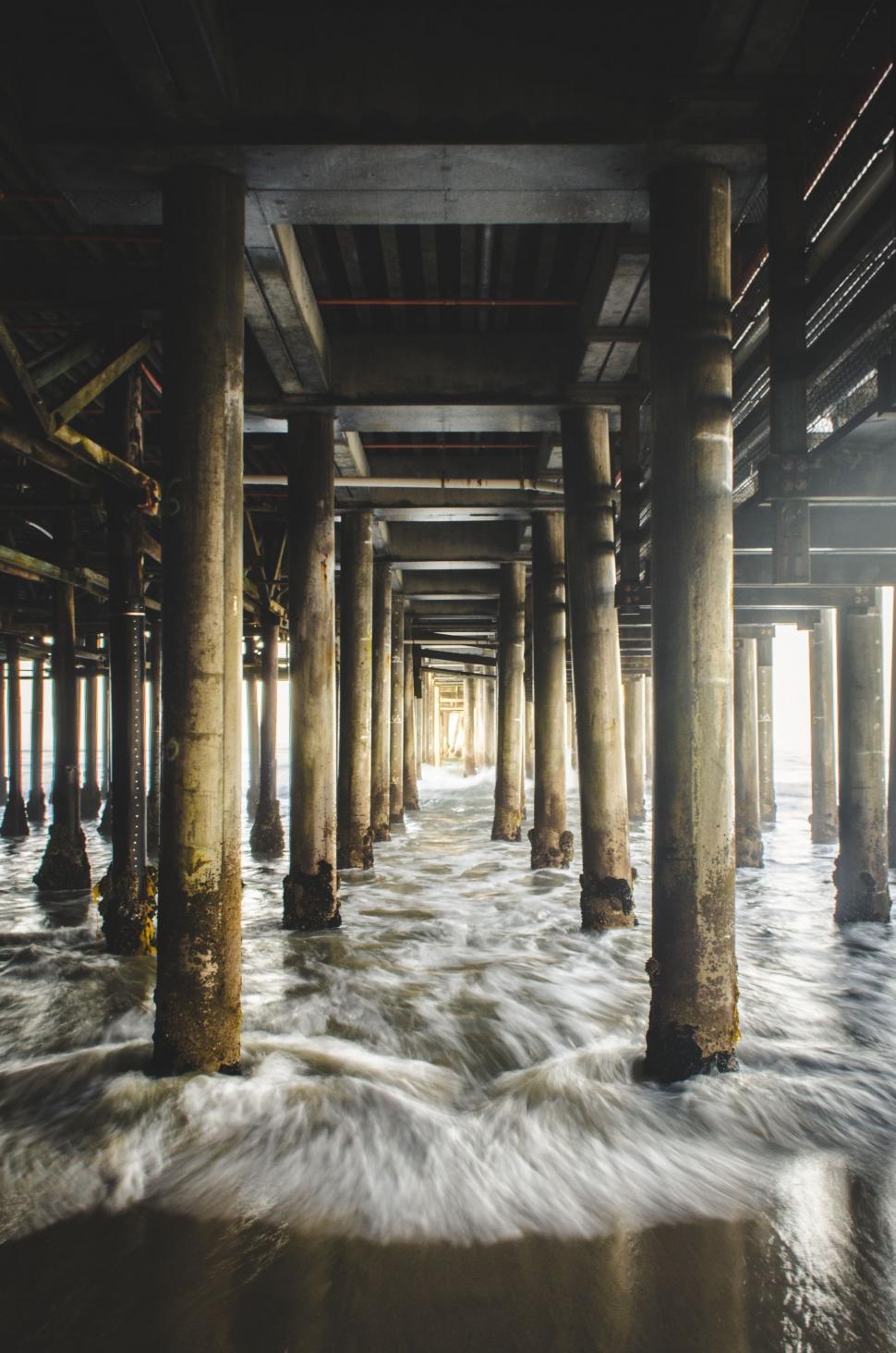 Free Image of Pier Filled With Water Under a Bridge 