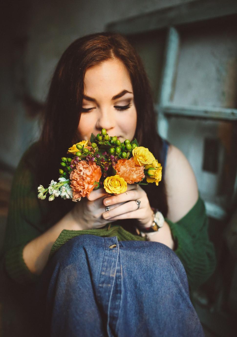 Free Image of Woman Sitting on Floor With Flowers 