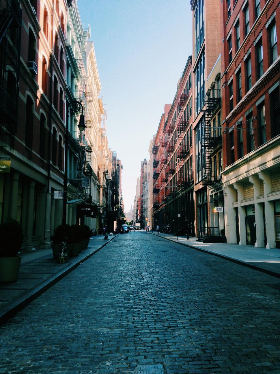 Free Image of Historic Cobblestone Street Flanked by Tall Buildings 
