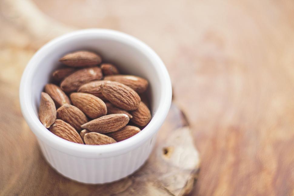 Free Image of White Bowl Filled With Almonds on Wooden Table 
