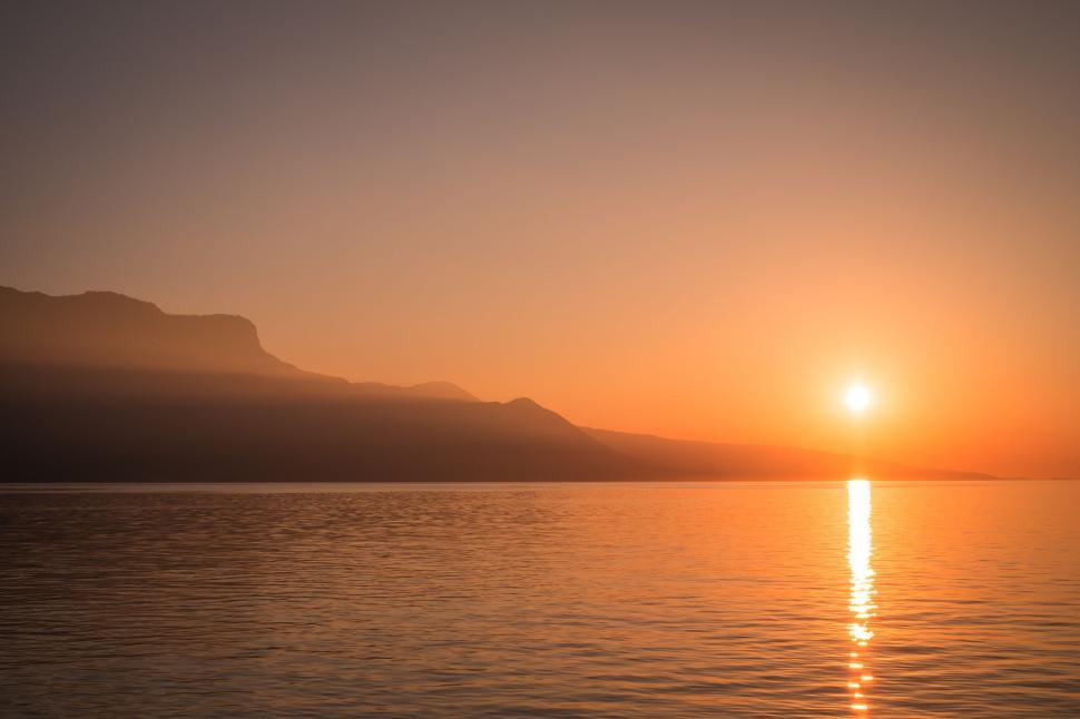 Free Image of Sun Setting Over Body of Water 