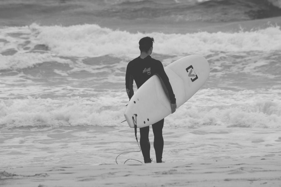 Free Image of Man Holding Surfboard in Ocean 