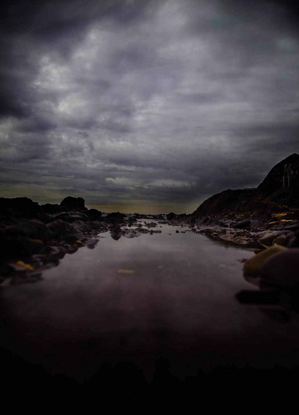 Free Image of Rocky Body of Water Under Cloudy Sky 