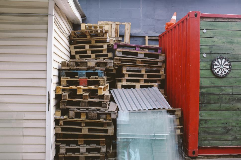 Free Image of Pile of Wooden Pallets Beside a Building 