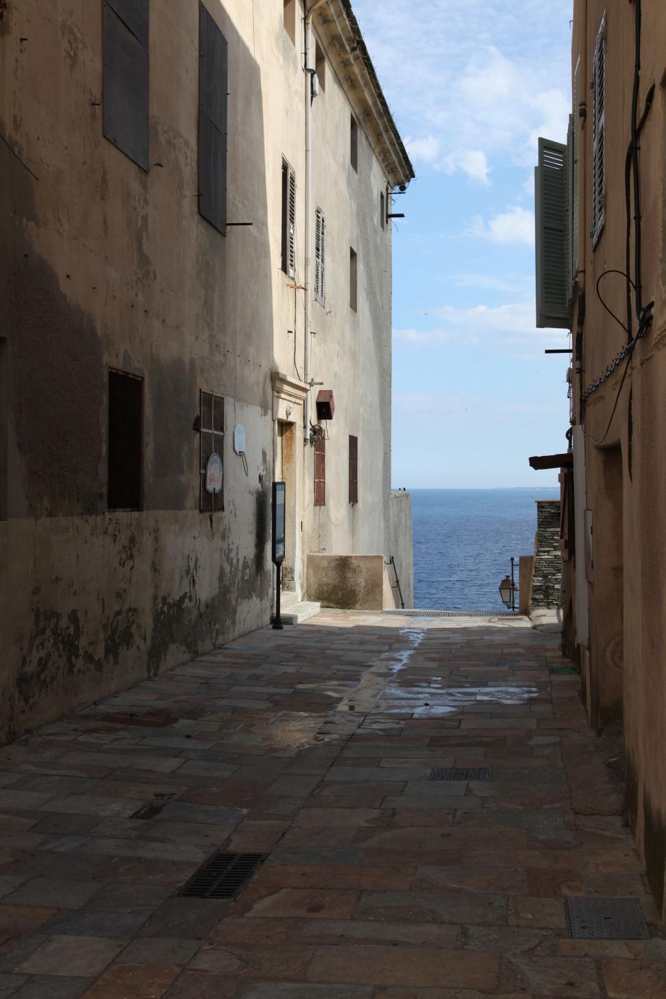 Free Image of Narrow Alley Way With a View of the Ocean 