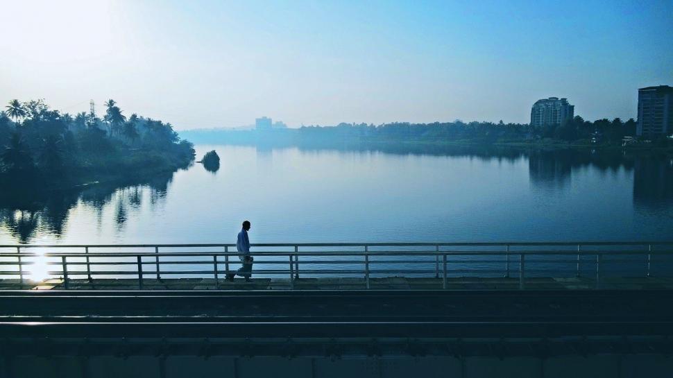 Free Image of Person Standing on Bridge Overlooking Body of Water 