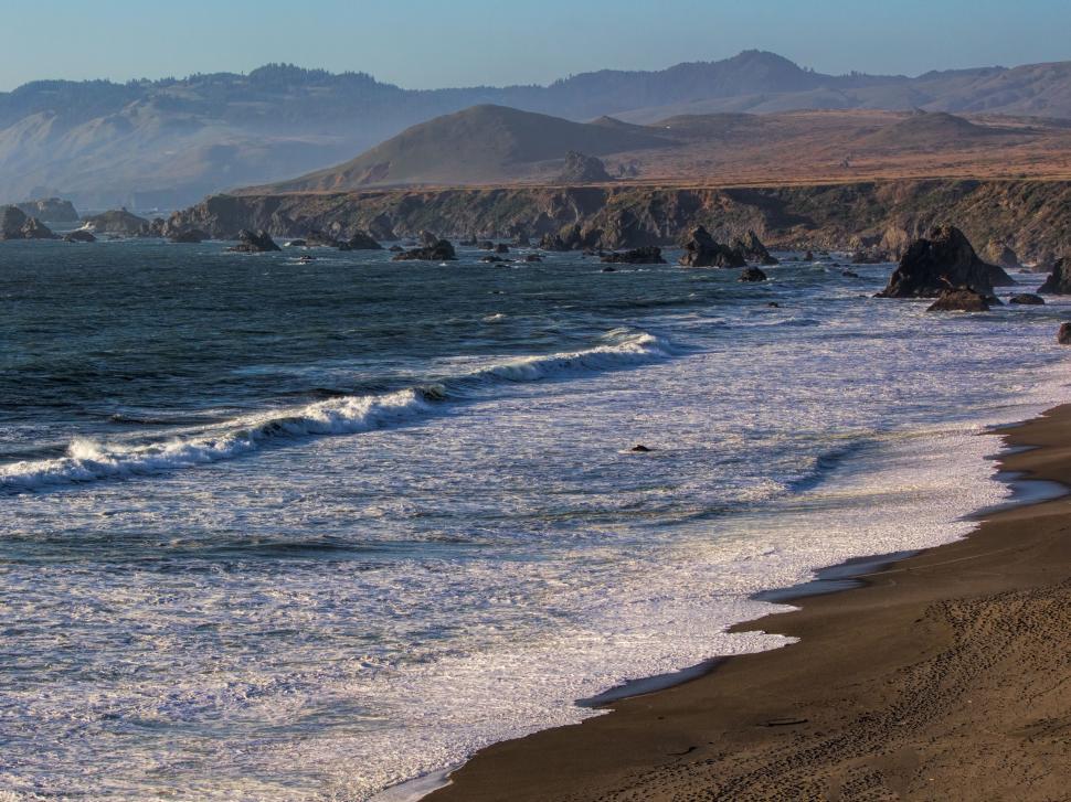 Free Image of Scenic Beach With Mountains in the Background 