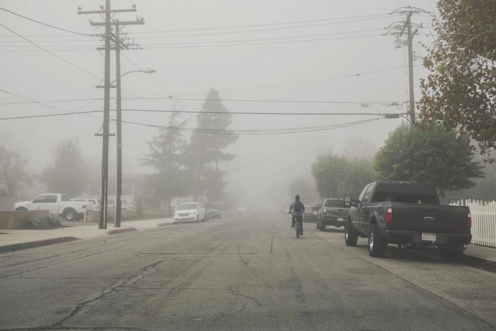 Free Image of Person Riding Bike on Foggy Street 
