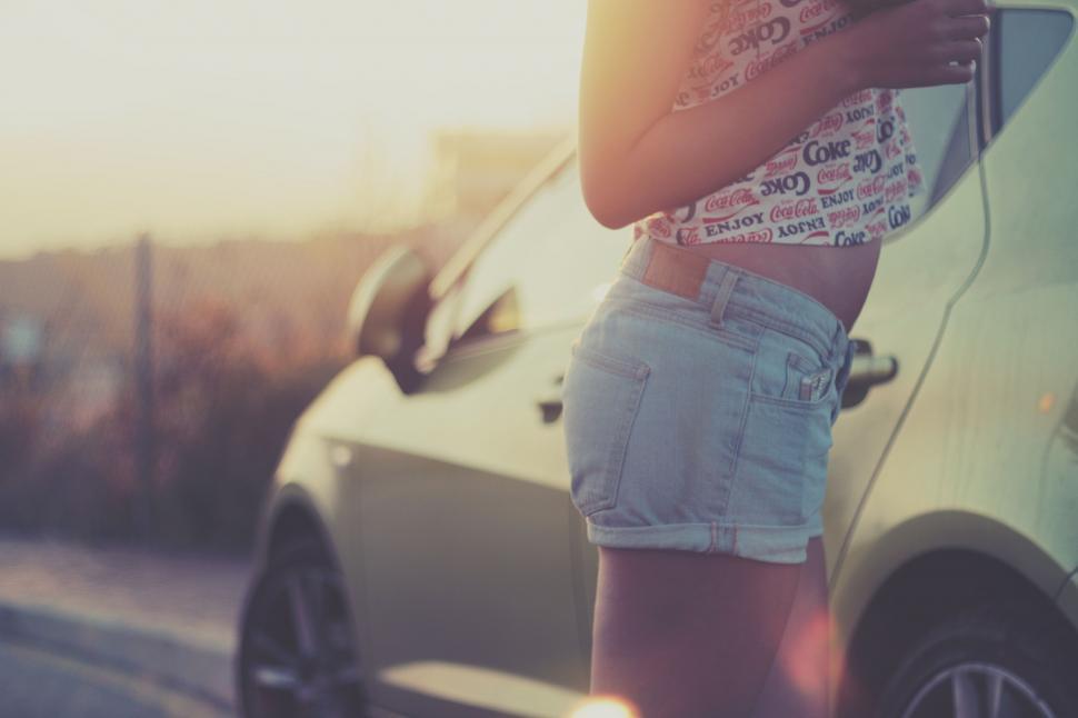 Free Image of Woman Standing Next to Parked Car 
