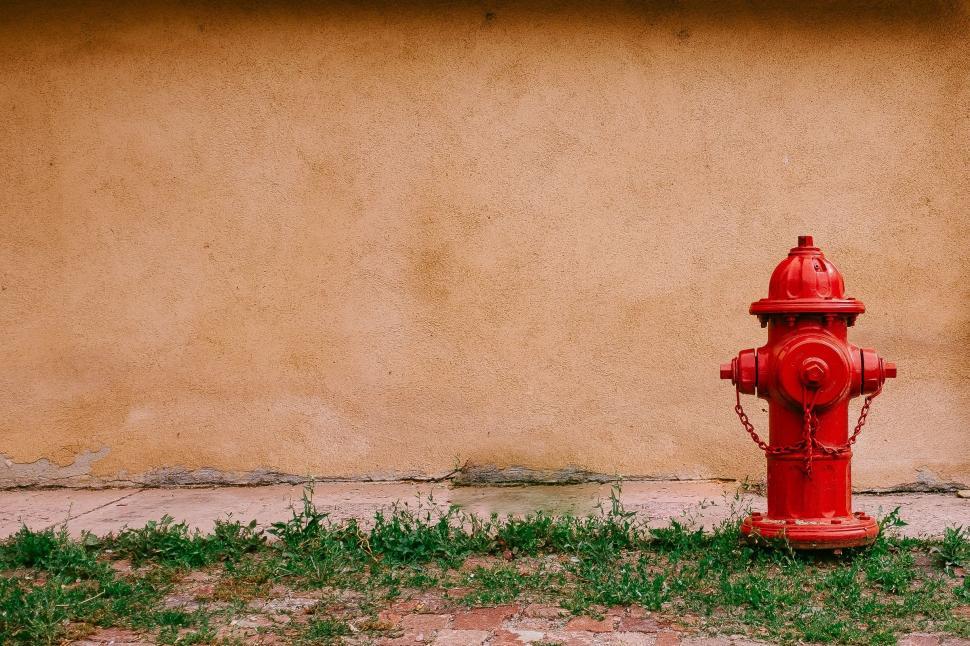 Free Image of Red Fire Hydrant Next to Wall 
