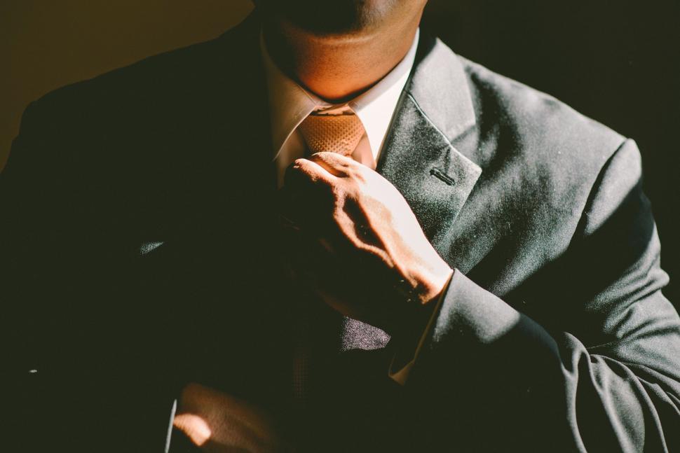 Free Image of Man in a Suit Adjusting His Tie 