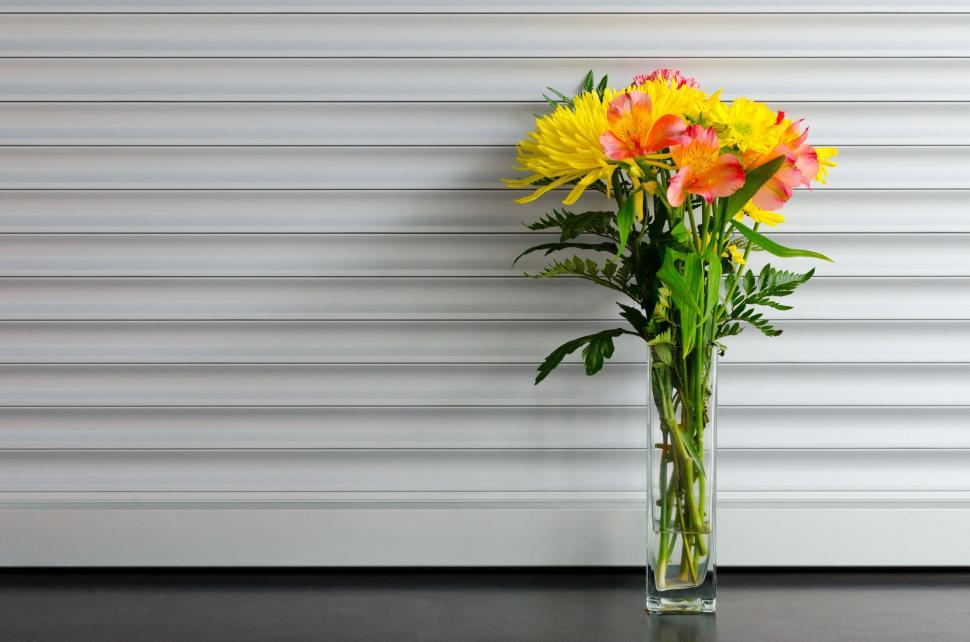 Free Image of Vase Filled With Yellow and Orange Flowers 
