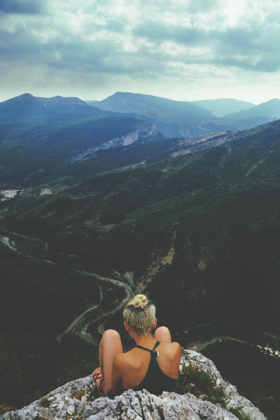 Free Image of Man Sitting on Rock Near Mountain 