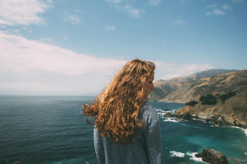 Free Image of Woman Standing on Cliff Overlooking Ocean 