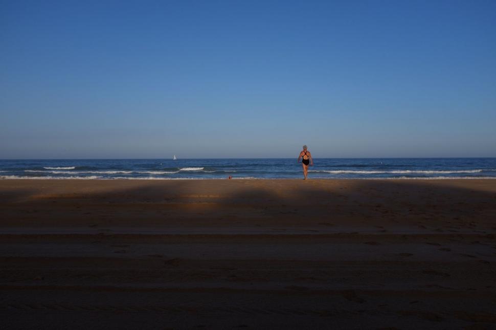 Free Image of Person Standing on Beach Near Ocean 