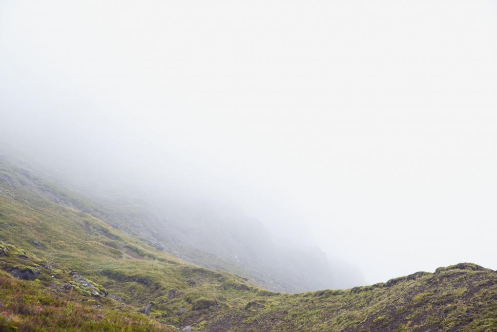Free Image of Person Walking Up a Foggy Hill 