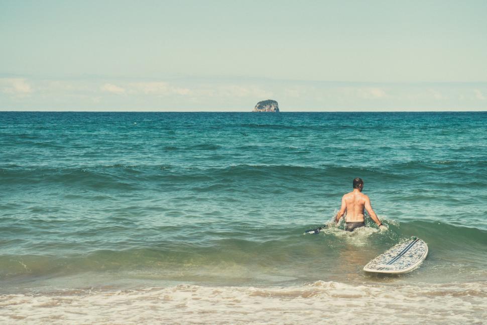 Free Image of Man Sitting on Surfboard in Ocean 