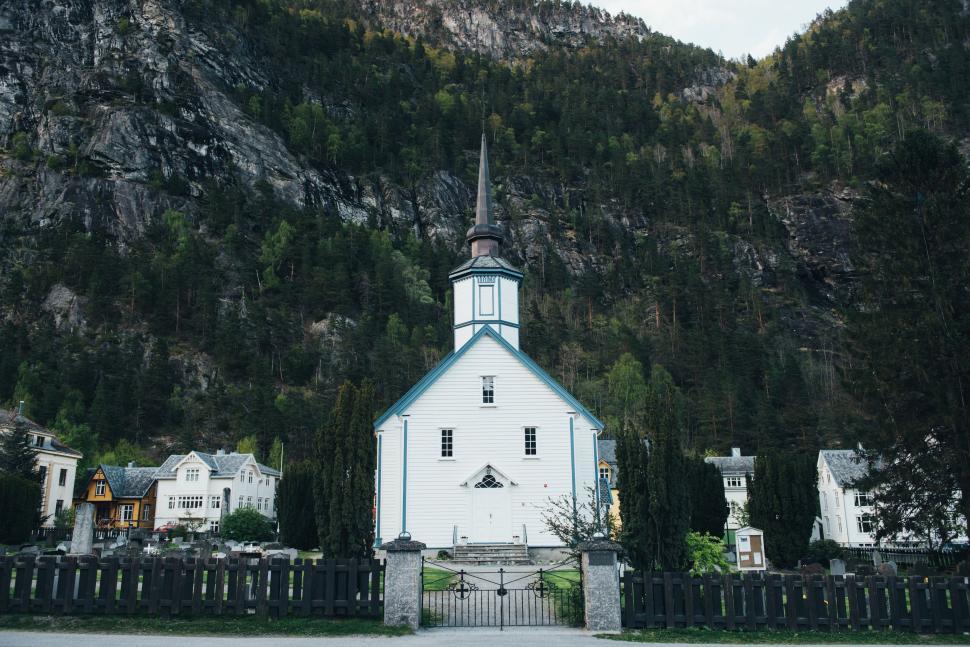 Free Image of White Church With Steeple in Front of Mountain 