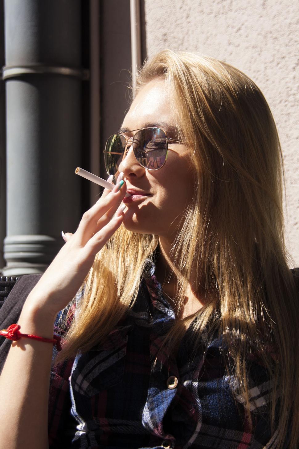 Free Image of Woman Smoking a Cigarette on City Street 