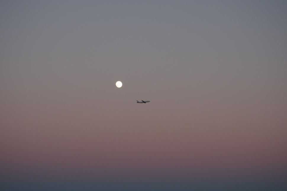 Free Image of Plane Flying With Moon in Sky 