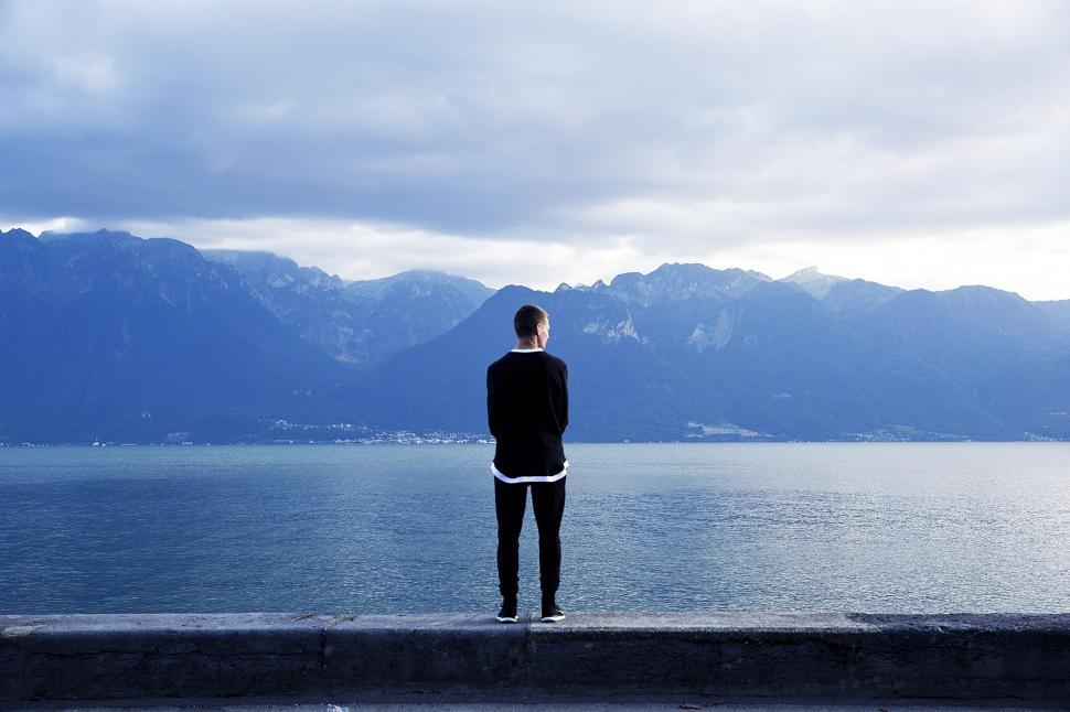 Free Image of Person Standing on Ledge Overlooking Body of Water 